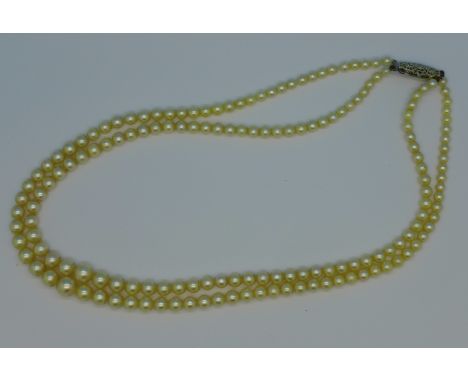 A string of two rows of cultured pearls on a silver clasp