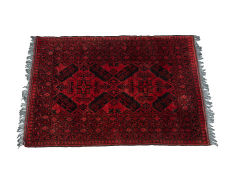 AN AFGHAN TURKOMAN WOOL RUG
The central field featuring a multiple stylised diamond design, within multiple foliate borders o