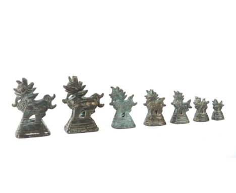 7 OpiumgewichteChina, 20. Jh., Bronze/dunkle Patina, je Fabeltier auf abgetrepptem Sockel in variierenden Größen, H: ca. 6,8-