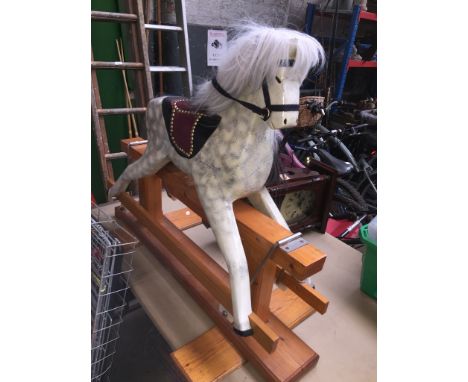 A vintage rocking horse with several cracks in the horse. 