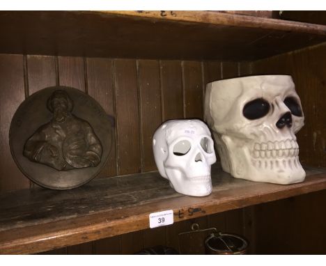 A resin Charles Dickens plaque, ceramic skull and a plastic skull bowl. 