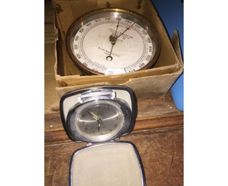 Aneroid circular barometer by Wilson Warden and Co London and a portable alarm clock 