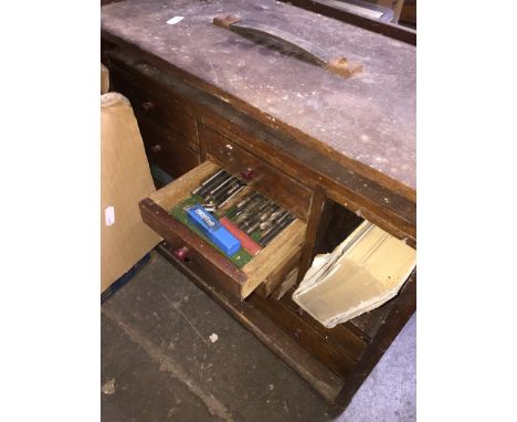 A multi-drawer wooden toolbox with tools. 