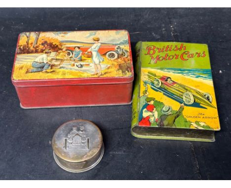 A British Motor Cars 'The Golden Arrow' book-shaped tin, one other depicting a picnic scene in front of a vintage car and a c