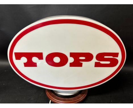 A Tops plastic petrol pump globe, faded to one side.