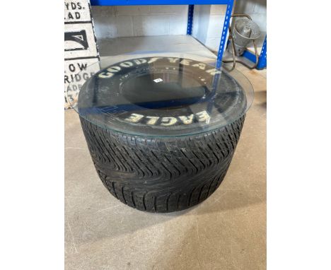 A Good Year Eagle F1 tyre with glass top forming a coffee table. 