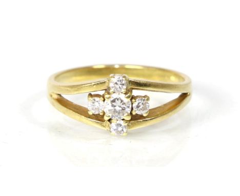 A diamond cluster ring, a round brilliant cut diamond within a border of four smaller diamonds, to forked shoulders, total es