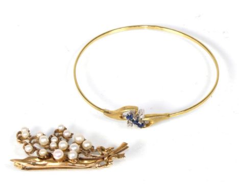 An 18 carat gold sapphire and diamond bangle, three round cut sapphires with two eight-cut diamond accents, to textured oval 
