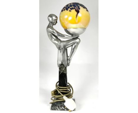 An Art Deco style figural table lamp in the form of a seated dancer holding a globe and raised on a marble column and stepped