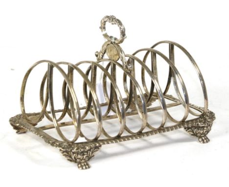 A William IV silver toast rack, mark possibly of Joseph Angell, London 1824, the gadroon rim with shell corners on foliate pa