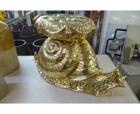 A gold painted plaster snail shaped stool 