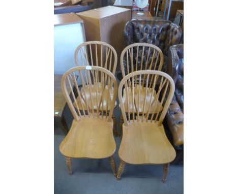 A set of four light oak Windsor style chairs 