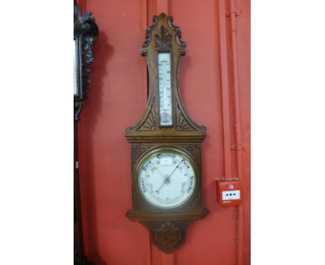 A Victorian carved oak aneroid barometer 