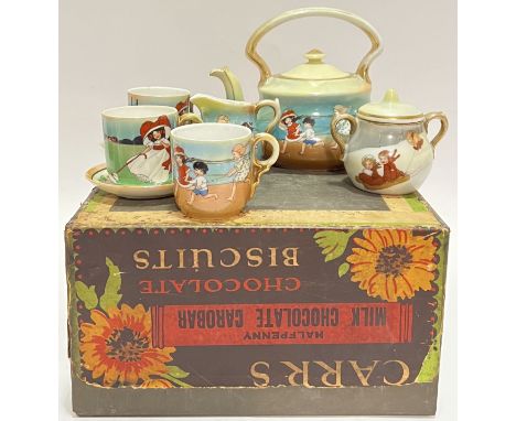 A miniature child's tea set decorated with children at play comprising three cups, two saucers, a milk jug, a teapot (h- 13cm