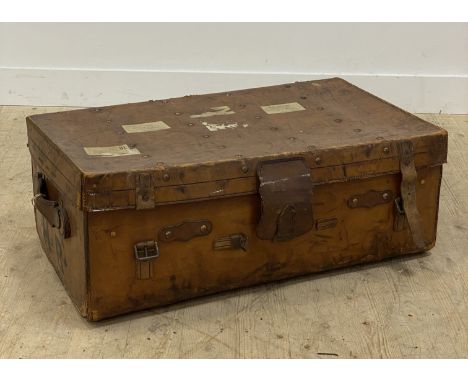 An early 20th century studded leather travelling trunk, the interior fitted with a tray, and having a carry handle to each en
