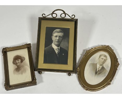 A Edwardian brass framed photograph of a man with scroll mount to top, (H x 21cm x W x13cm), an oval gilt framed photo of a y