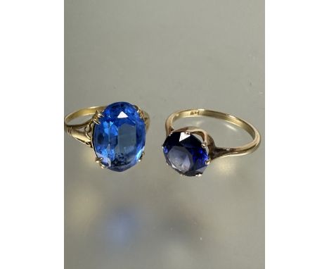 A 9ct gold solitaire ring set blue coloured circular faceted stone, L (D x 0.7cm) mounted in eight claw setting and a 9ct gol