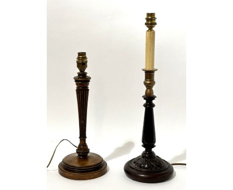 A carved oak table lamp raised on circular base (h-35cm), together with a stained wooded carved candle stick style table lamp