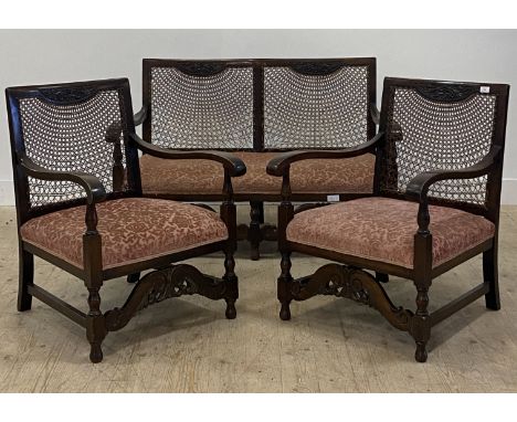 A 1930's three piece walnut and bergere drawing room suite, comprising a pair of armchairs (H84cm, W62cm) and a two seat sofa