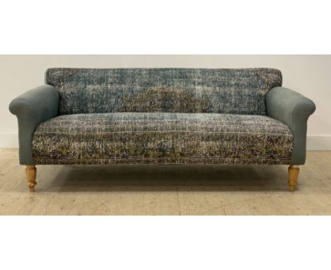 A large contemporary sofa, retailed by Anthropologie, the arms upholstered in a dusky blue loose weave linen, and seat and ba