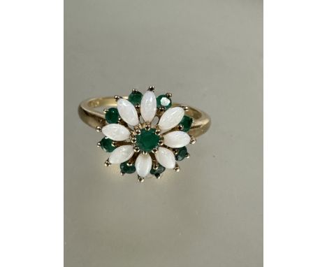 A 9ct gold opal and emerald floral cluster ring, the centre set emerald with surround of eight navette shaped opals all mount