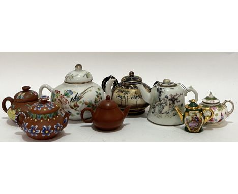 A group of miniature teapots comprising three Chinese Yixing redware teapots (two with enamelled decoration, the other with f