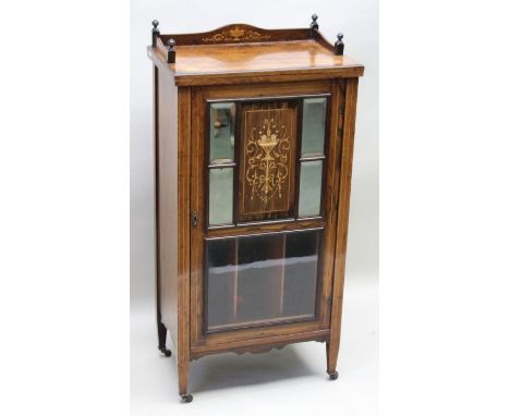 An Edwardian inlaid rosewood music cabinet, with gallery top, single door with marquetry central panel, flanked by four mirro