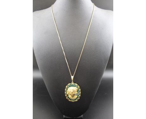 A 9ct gold mounted pendant, polished green stone with Classical portrait decoration, having diamonds set into her floral garl