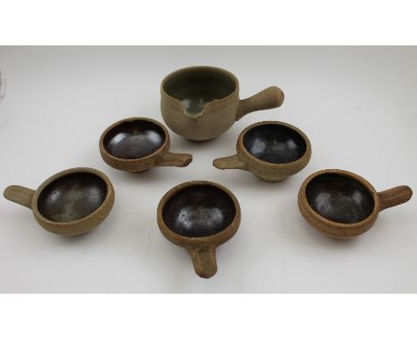 A 20th century "Leach" pottery stoneware bowl with pouring lip and side handle, together with five single handled small bowls