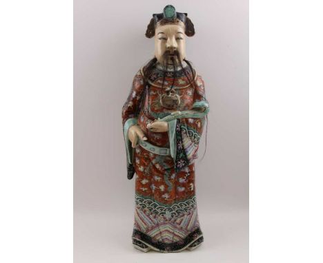 An early 20th century Chinese ceramic Immortal, carrying a Ruyi sceptre, polychrome painted in an elaborately decorated robe,