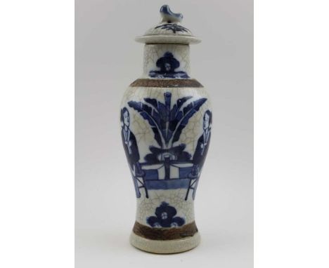 A 20th century Chinese ceramic vase, with crackle glaze, of baluster form, cobalt painted with Bejin, in garden, having cover