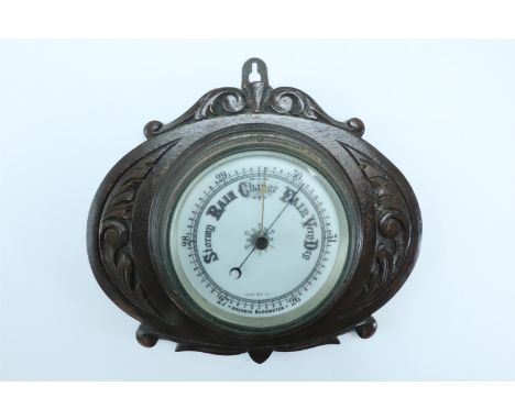 A carved oak aneroid barometer, 22 x 26.5 cm 