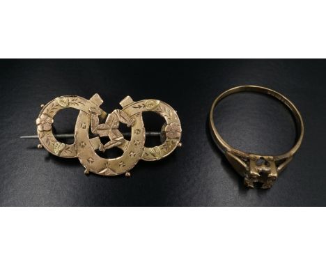 An early 20th Century 9 ct yellow metal 'Manx' brooch, having the triskelion on intertwined horseshoes with floral decoration