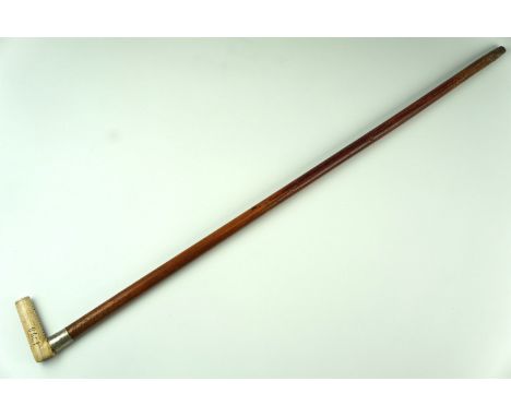 An early 20th Century malacca walking stick, having an L shaped antler handle naively carved having a Latin cross to the top,