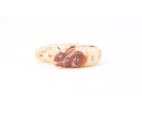A Chinese carved jade pendant or toggle in the form of a rabbit and vine fruit, 33 mm