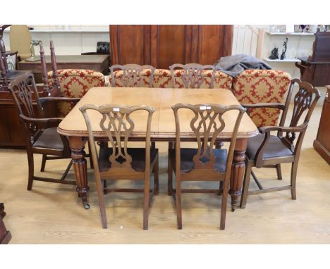 A Victorian mahogany wind out dining table, having heavily reeded legs and two extra leaves, together with six reproduction C