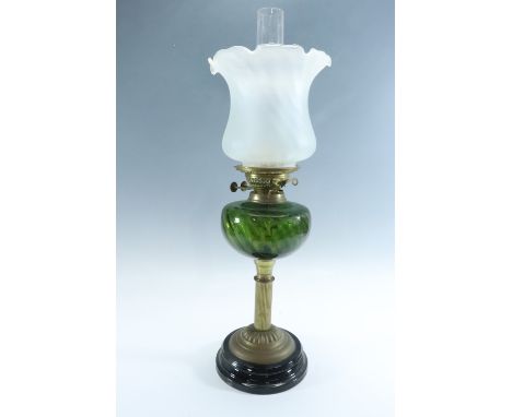 A Victorian columnar brass and emerald glass oil lamp, having a duplex coronet burner and an opaque crinoline edged shade, 55