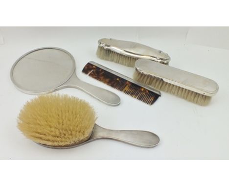 A FOUR PIECE SILVER MOUNTED ENGINE TURNED DRESSING TABLE SET, comprising hand mirror, comb, two brushes, London 1961, togethe