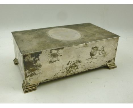 AN ENGINE TURNED SILVER CIGARETTE BOX, the hinged lid with vacant frame mount, raised on four stepped feet, 18cm wide, Birmin