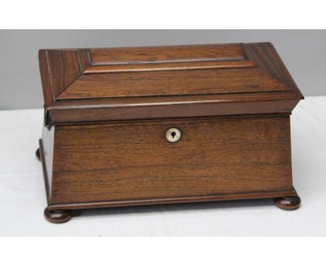 A 19TH CENTURY ROSEWOOD TEA CADDY of sarcophagus form, the lid opening to reveal two inner lidded containers either side of a