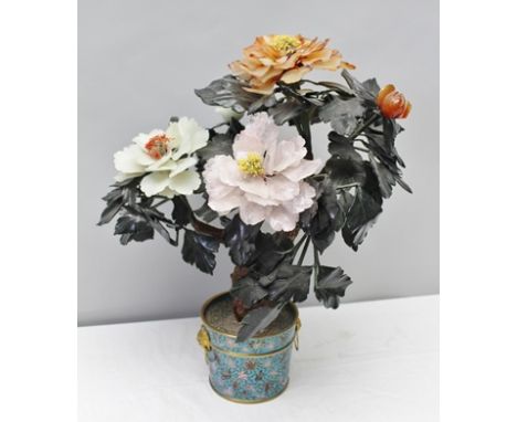 A CHINESE HARDSTONE PLANT with colourful blooms and buds, possibly peony, with dark jade green leaves, within a cloisonne pla