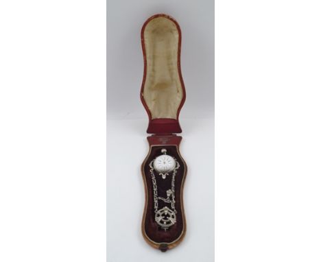 A LATE VICTORIAN/EDWARDIAN WHITE METAL CHATELAINE WATCH, having sash/belt clip, fancy chains suspending a domed glass lens wa