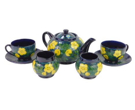 A Moorcroft pottery Buttercup pattern tea service, designed by Sally Tuffin, comprising teapot, 12cm high, two teacups and sa