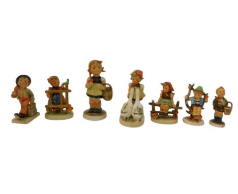 Seven Goebel Hummel figures, to include young girl holding a basket, 14cm high, a boy seated on an apple branch, 10cm high, e