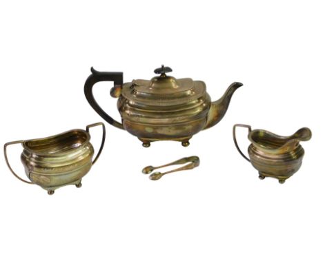 A George V silver three piece tea service, comprising teapot, twin handled sugar bowl and milk jug, of bellied form with a ga