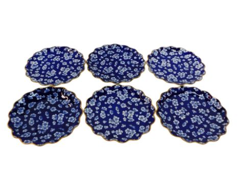A set of six Coalport porcelain dessert plates, each with a waved border decorated with white flowers against a Royal blue gr
