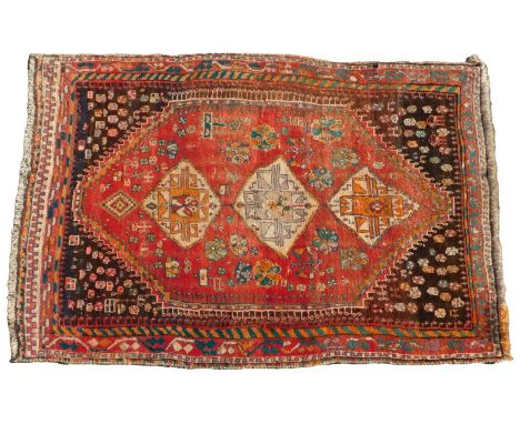 A Persian carpet, with a design of medallions, and geometric motifs, on a red ground, with dark brown spandrels, one wide, tw