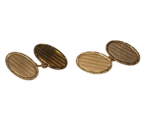 A pair of 9ct gold cufflinks, of oval form, engine turned and engraved foliate scroll decoration, 9.7g. 