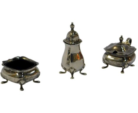 A George V silver three-piece cruet, comprising a lidded mustard pot, open salt and a pepper pot, each with a fluted border, 