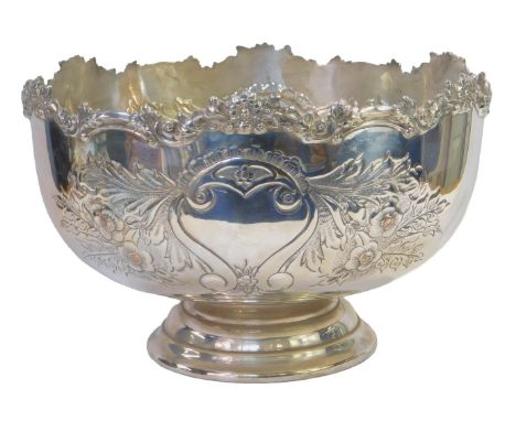 A silver plated punch bowl, embossed with scrolls, flowers, leaves, etc., on a circular stepped base, 23cm high, 36cm diamete